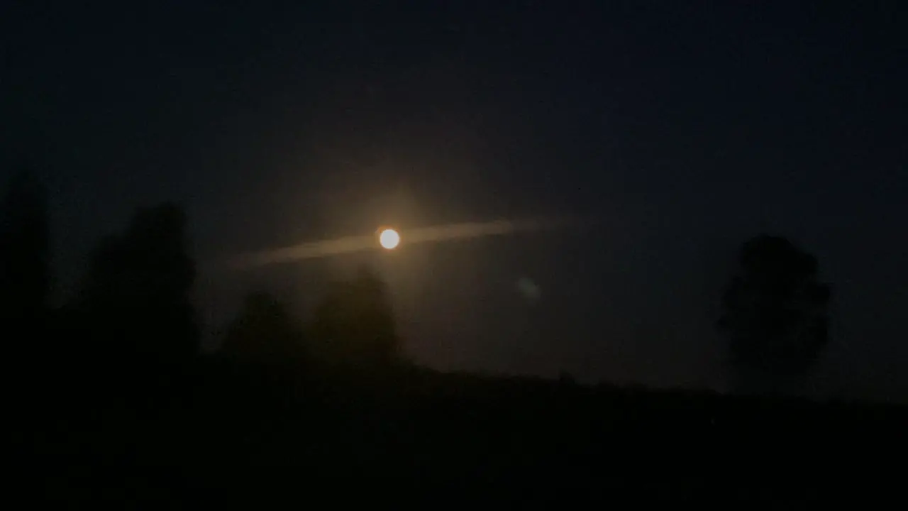 Yellow moon in foreground from car driving