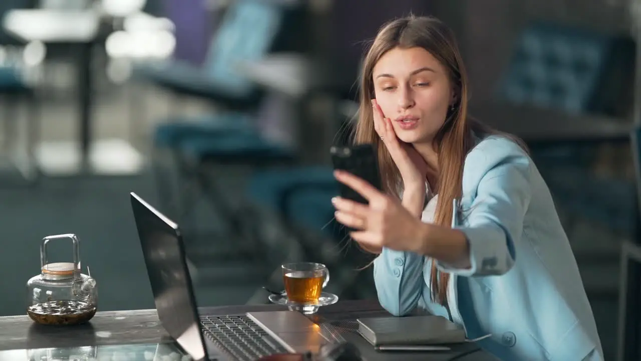 portrait of stylishly dressed pretty girl taking a selfie on the phone