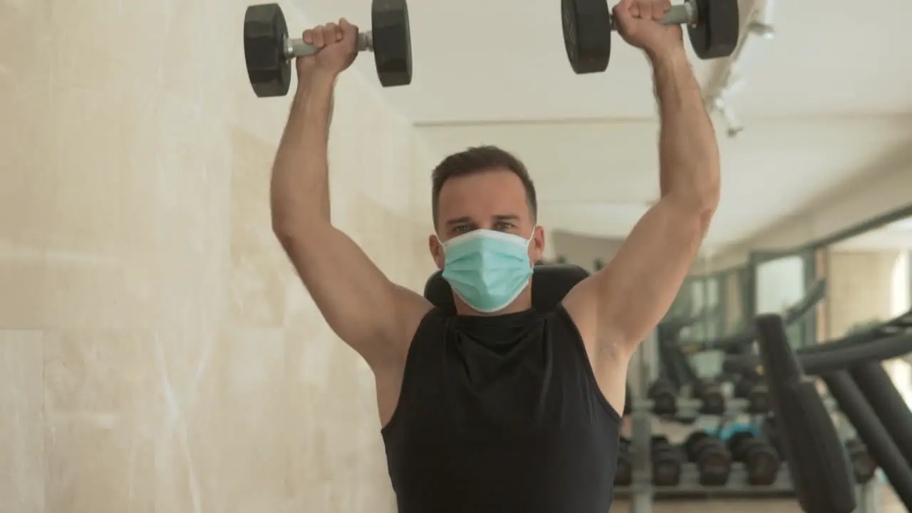 Strong Male With Face Mask Lifts Weights And Exercises In The Gym