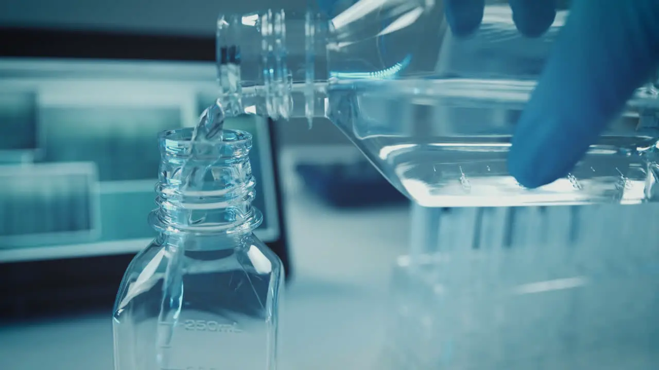 Liquid in lab is poured from one lab vessel to another