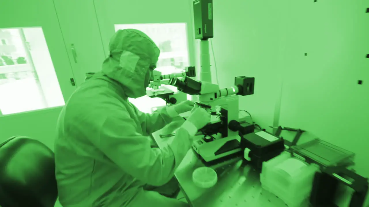 Laboratory worker using a microscope in a scientific lab Dolly Close Up