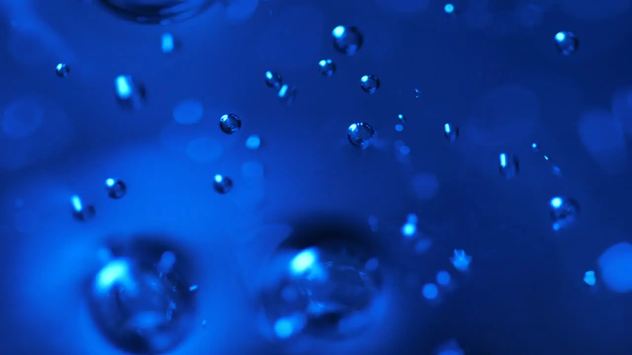 Blue abstract bubbles rising in liquid