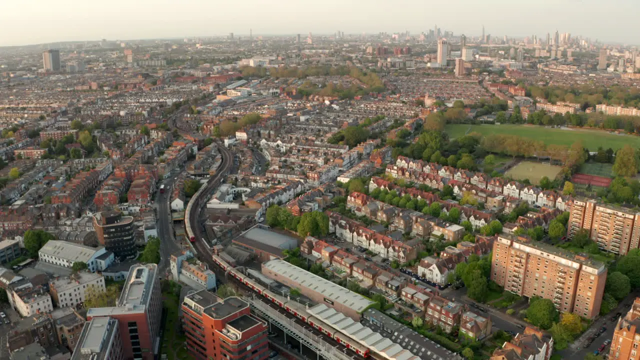 Aerial shot over District line underground train in west london neighbourhood Fulham looking towards the city skyline