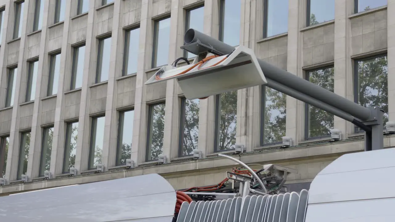 Close up of a lowering pantograph and electric bus departing