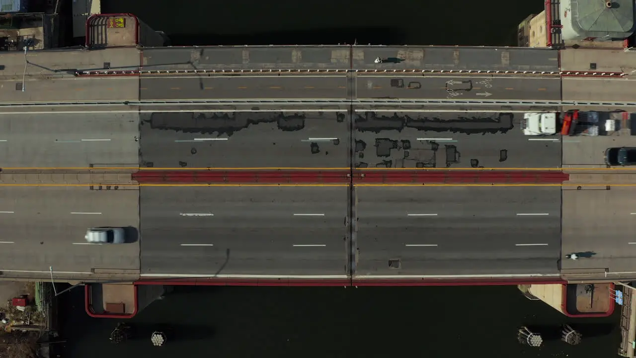 Aerial birds eye overhead top down ascending shot cars driving on multilane road bridge over water Bascule bridge from height New York City USA