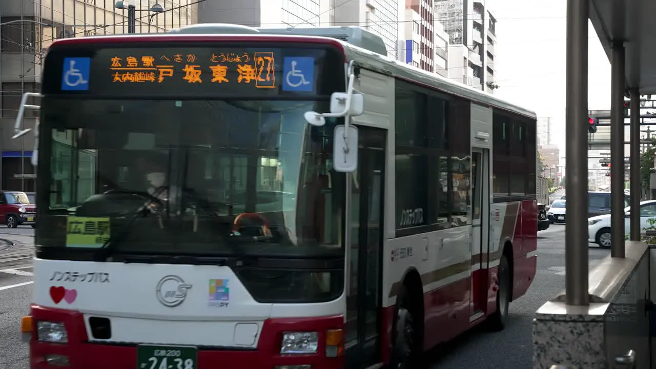 Local busses driving on the city streets of Hiroshima urban city static shot