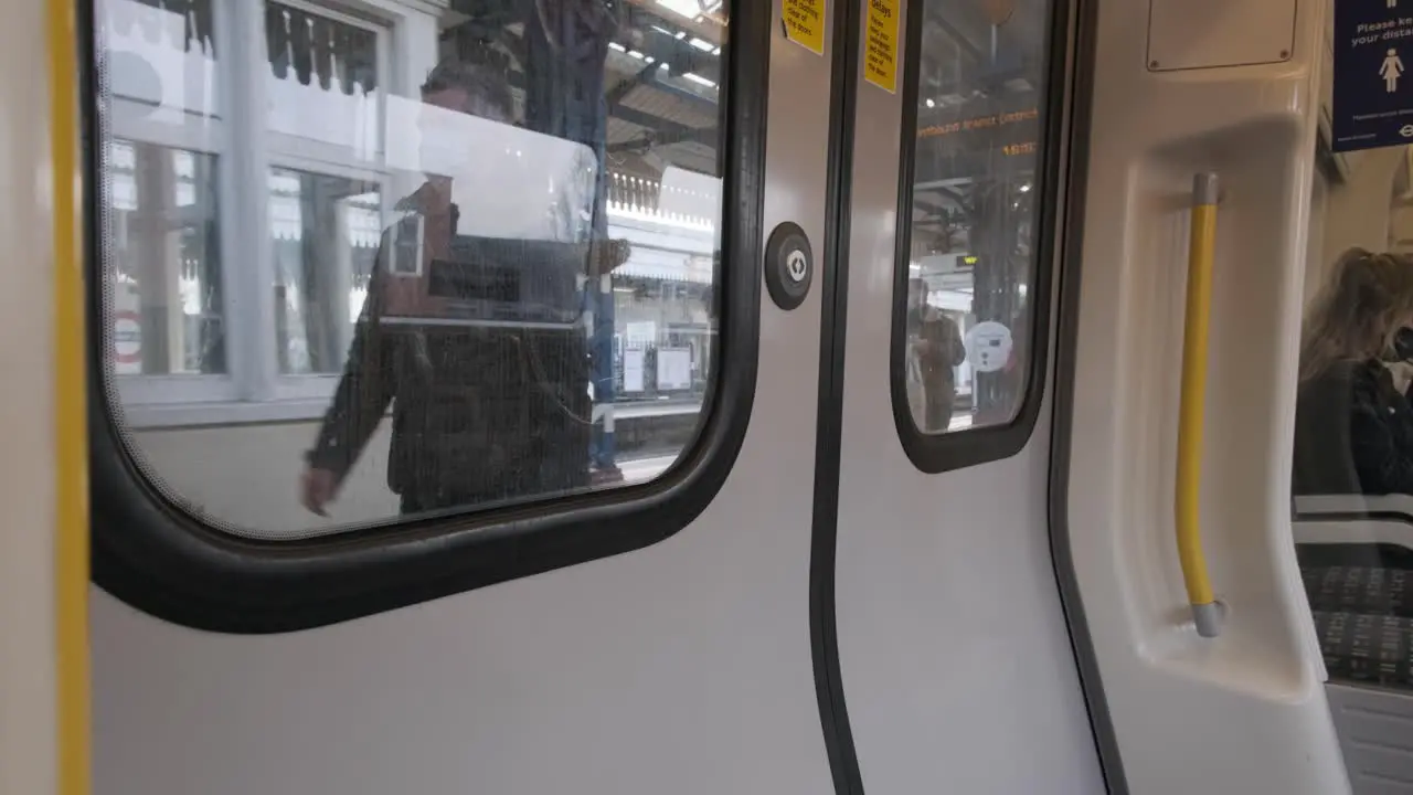 London underground District line train pulling into Turnham green railway station from inside