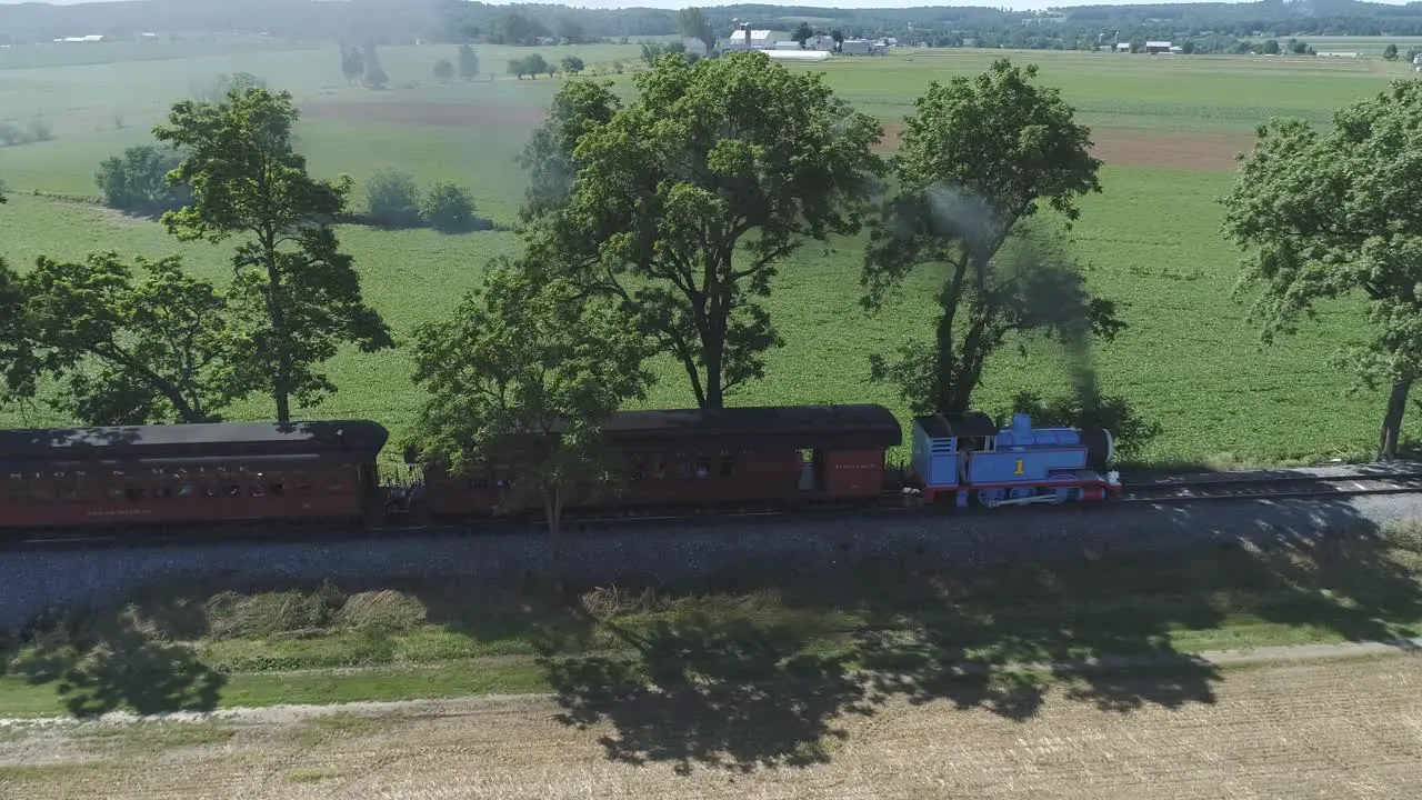 Aerial View of a Thomas the Tank Engine with Passenger Cars Puffing along Amish Countryside