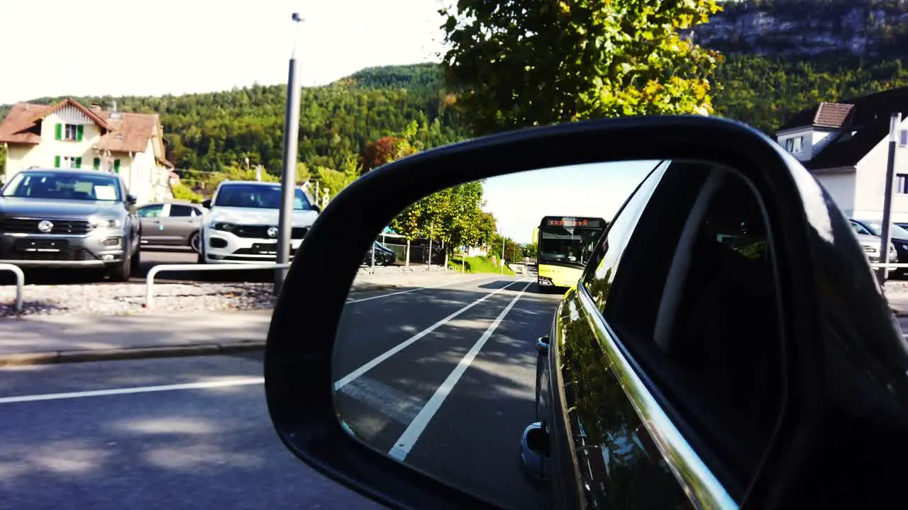 Car running on the road while Austrian yellow bus is following it and other on coming vehicles in the other lanes