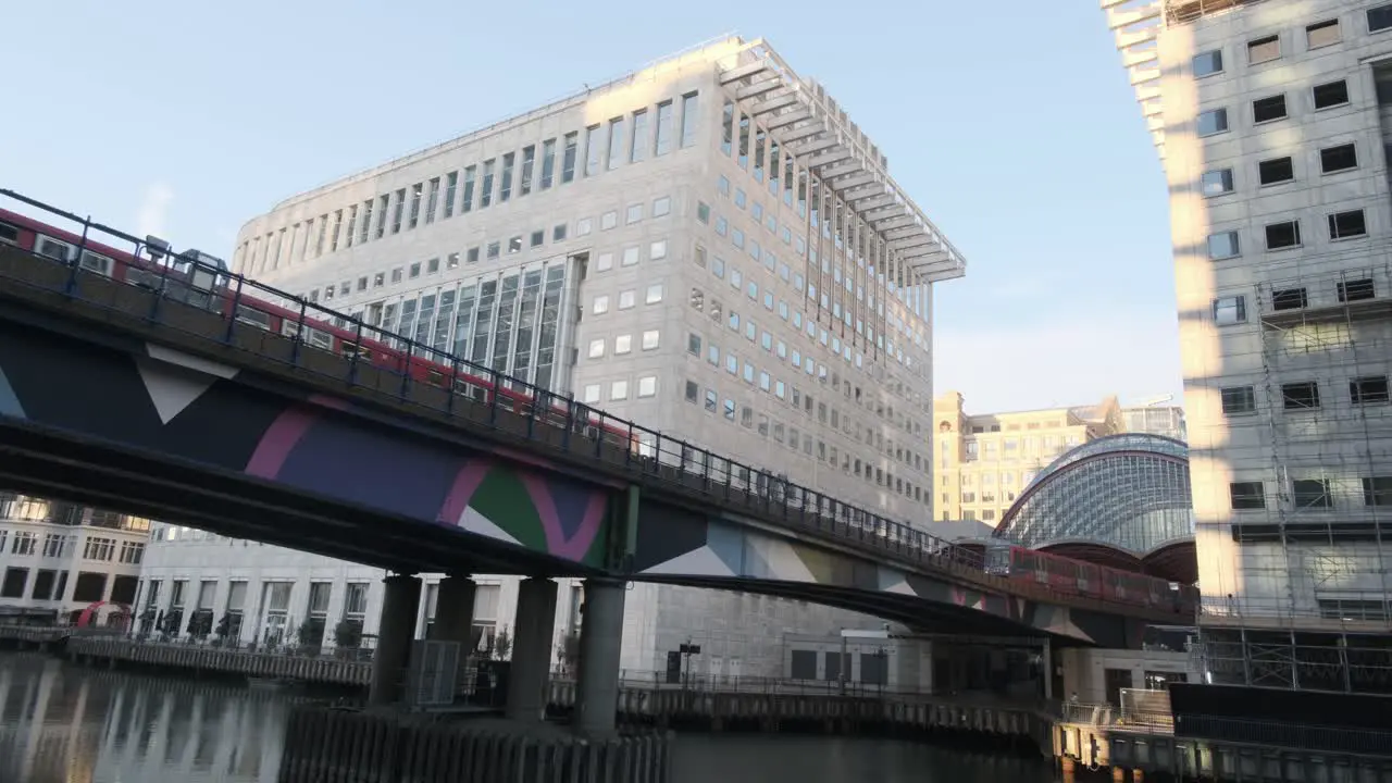 Two London DLR trains pass each other on bridge over middle dock Canary Wharf London