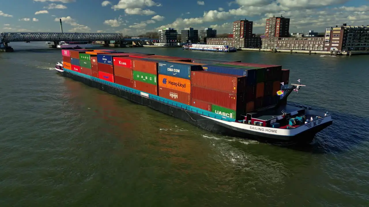 Cargo ship with containers navigating through the city of Zwijndrecht in The Netherlands