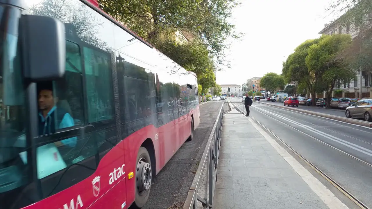 Red ATAC Bus Driving on City Street in Rome Italy