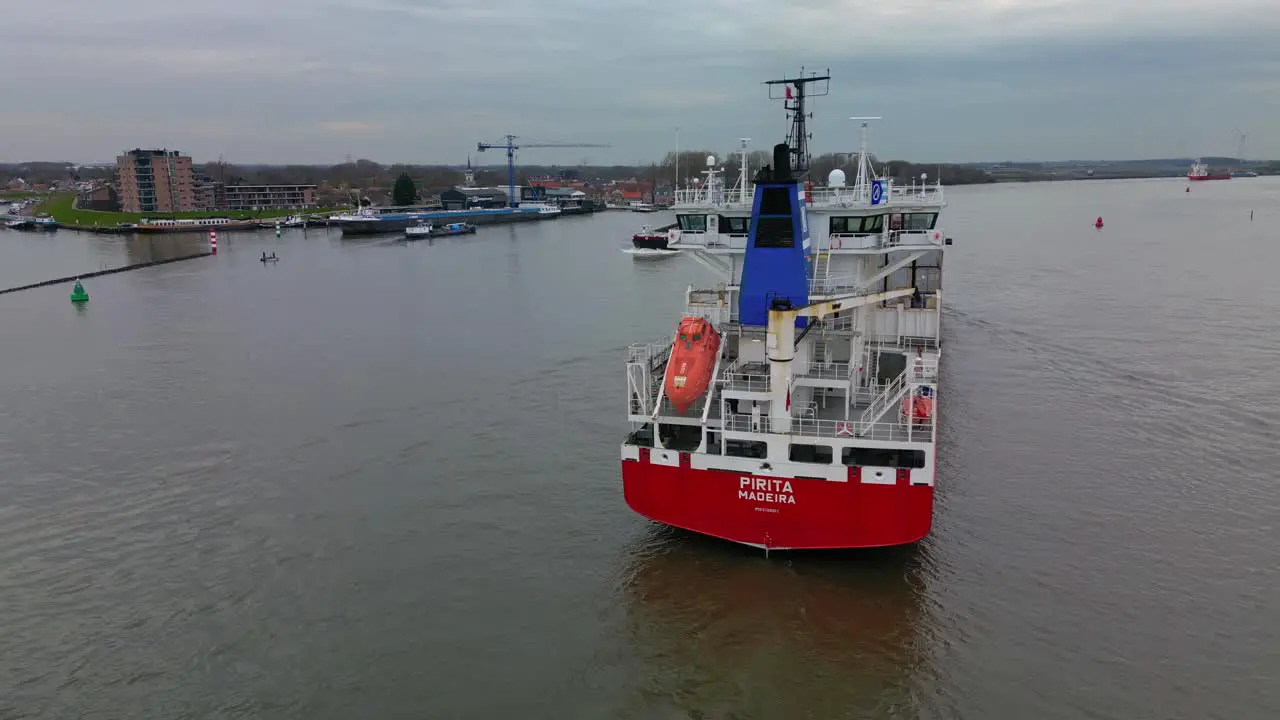 Big Cargo carrier ship navigating through the canal of Zwijndrecht aerial view