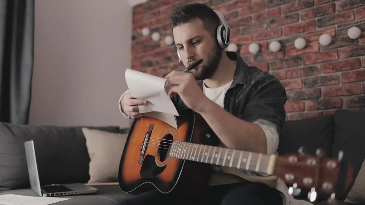 Young Musician Man Creating Music Having Ideas Taking Notes At Home