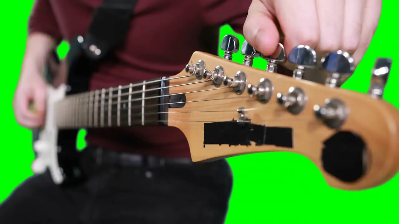 Mid section male musician adjusting tuners