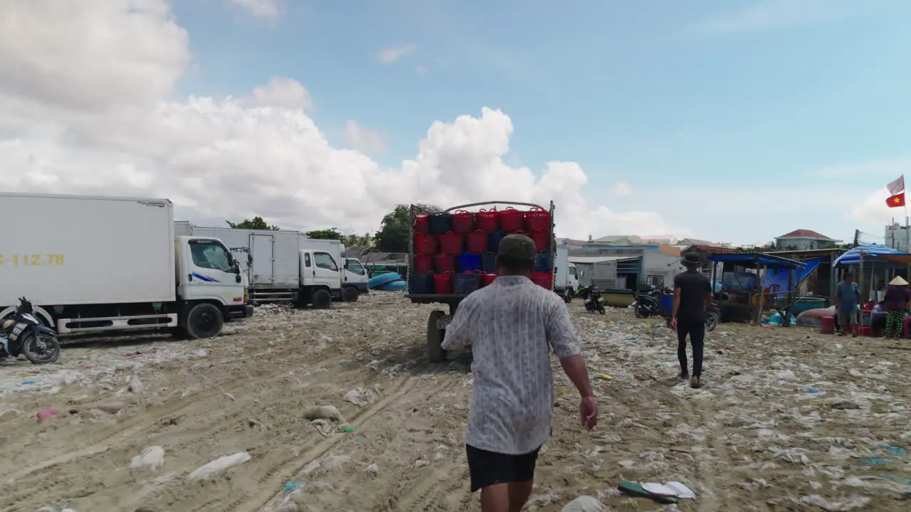 POV of fishermen assisting loaded transport truck with fish baskets