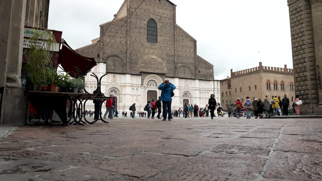 Red Bus Driving Past Along Piazza Re Enzo Near Piazza Maggiore With Basilica of San Petronio In The Background