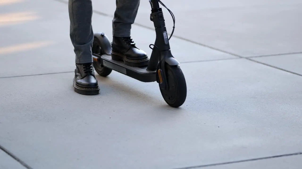 close up shot of a businessman arriving with his e-scooter