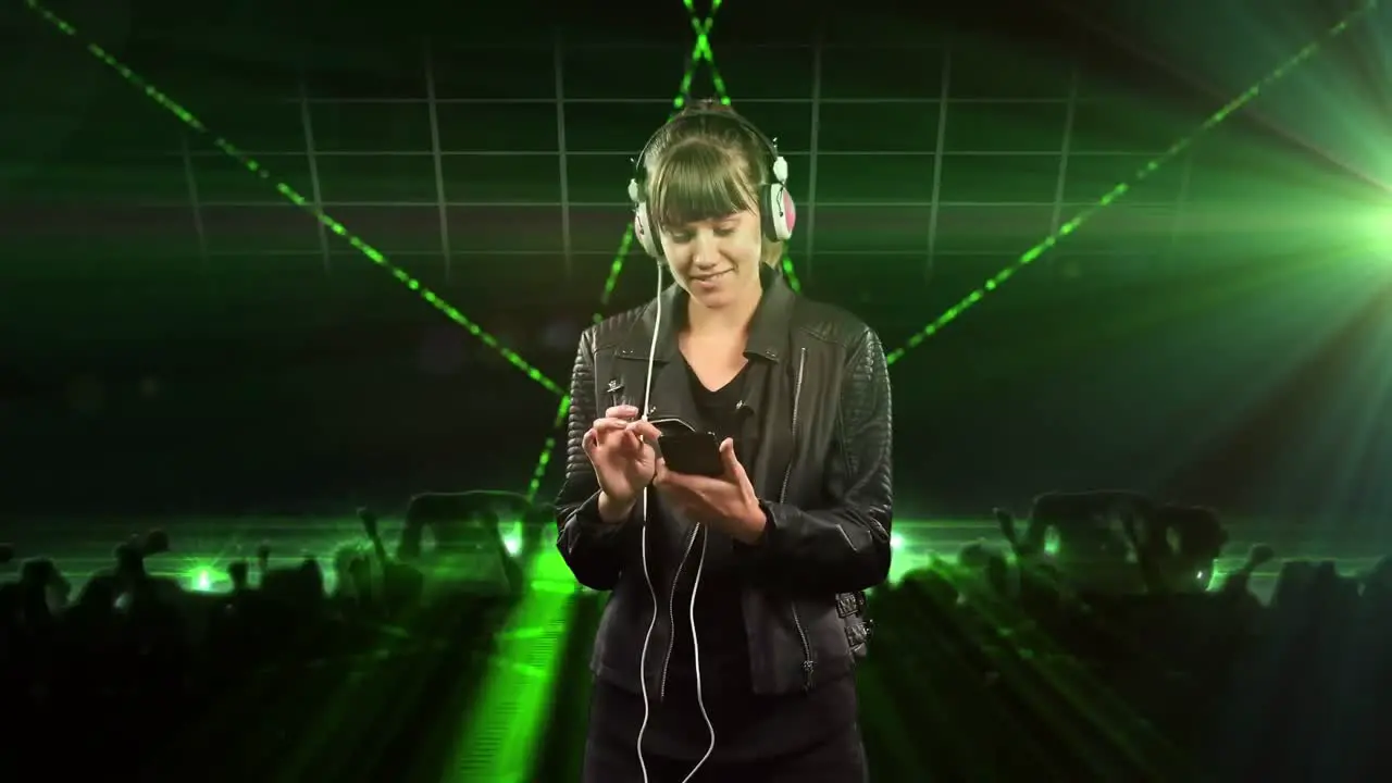 Animation of happy caucasian woman with smartphone and headphones over green lasers