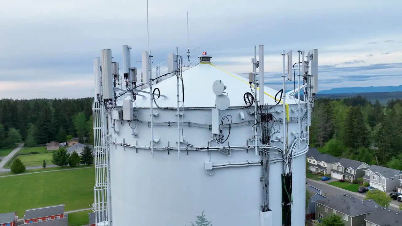 Close up aerial shot of the many pieces of telecommunication equipment on top of a water tower