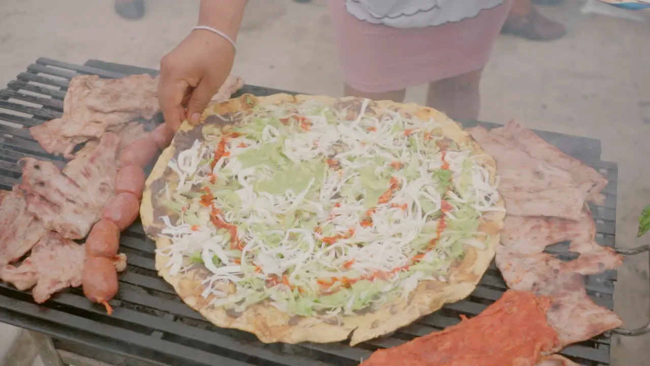 Preparing traditional Food Tlayuda with traditional Oaxaca cheese Quesillo