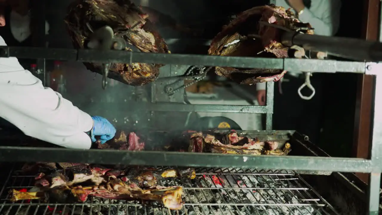 chef wearing plastic gloves cooking grill bbq meat in professional kitchen of restaurant