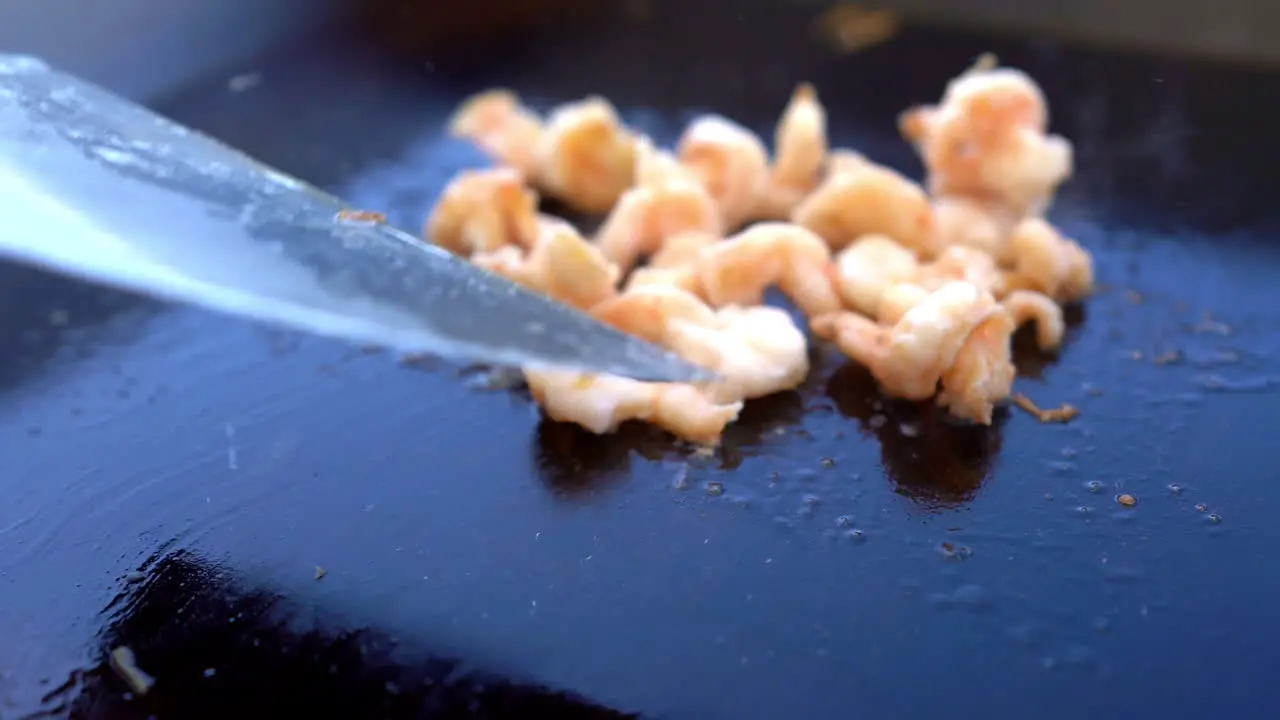 Flipping shrimp on the grill close up