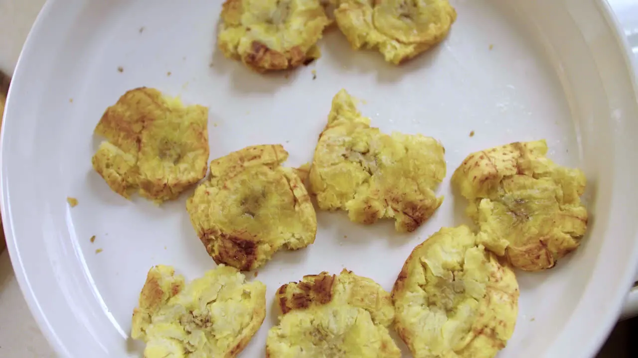 Plano cenital de comida peruana con un plato lleno de patacones o tostones recién cocinados en la selva peruana