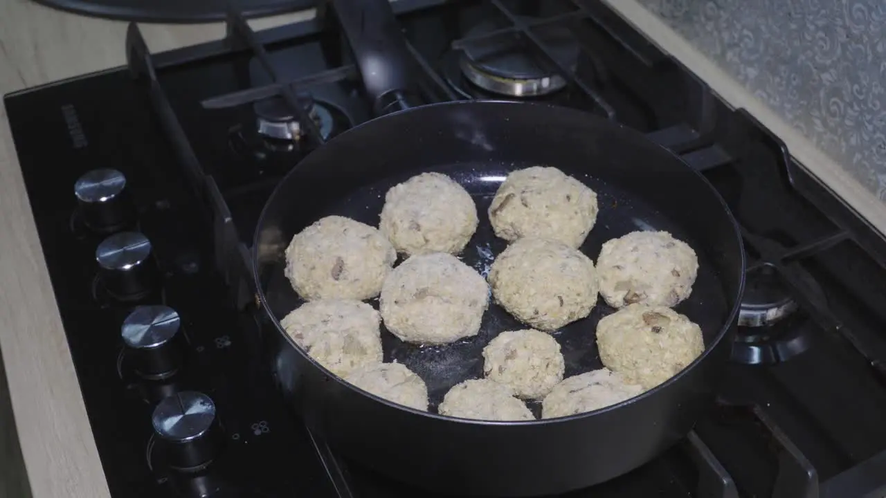 Tofu cutlets are fried in hot oil in a pan the camera moves around the pan