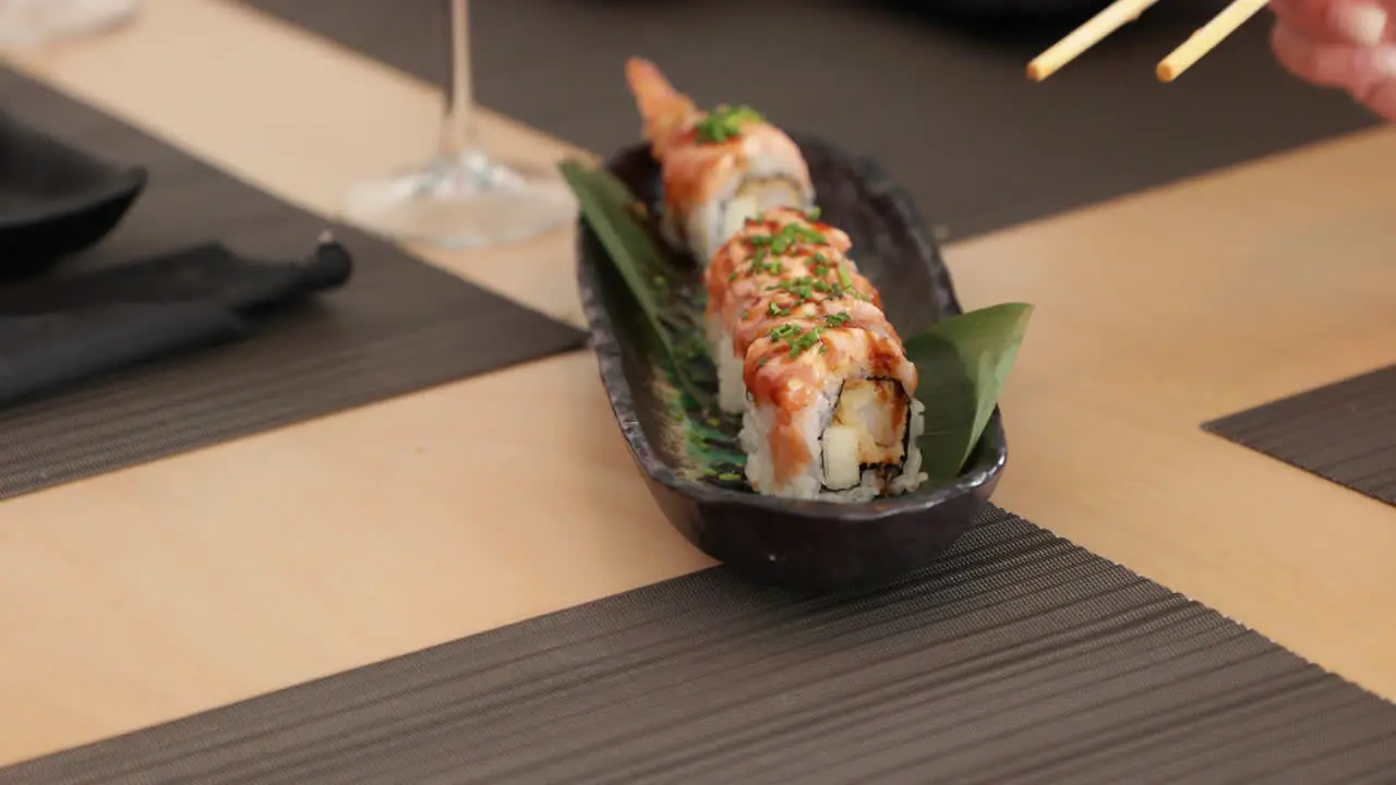 Eating Shrimp Tempura Sushi Rolls With Chopsticks In A Japanese Restaurant close up