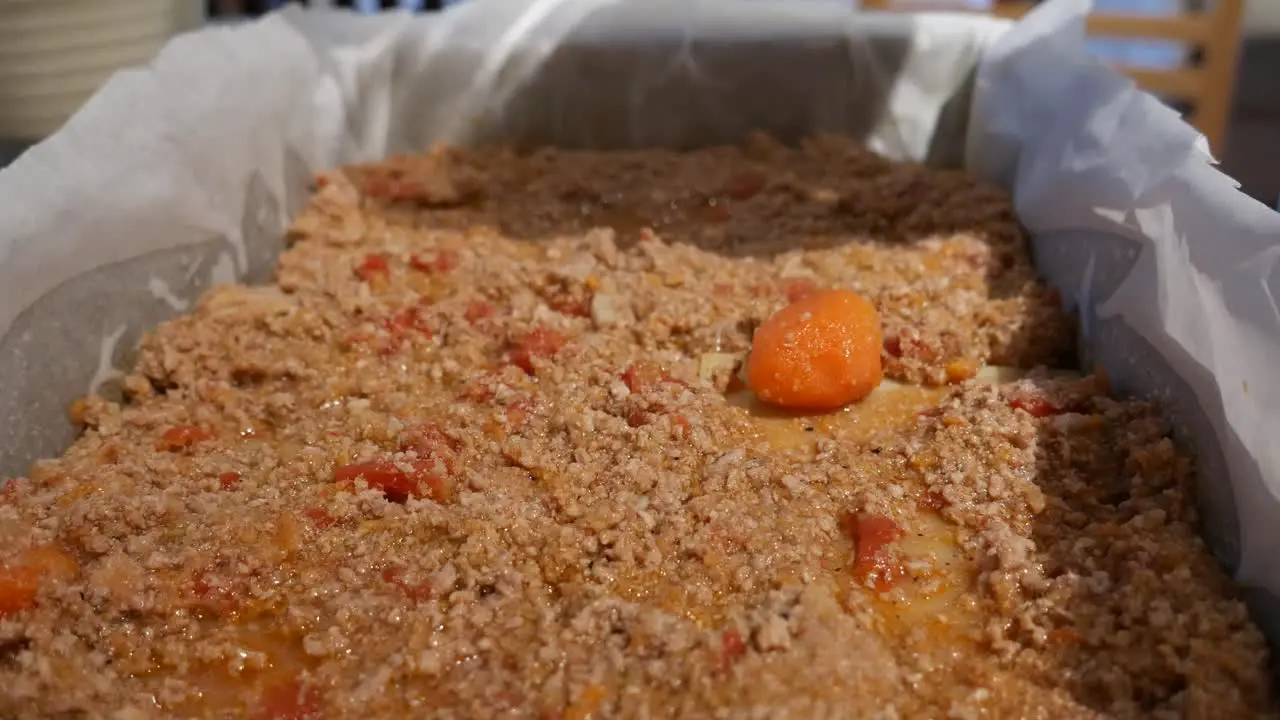 lasagne assembly adding parmesan cheese to mince meat