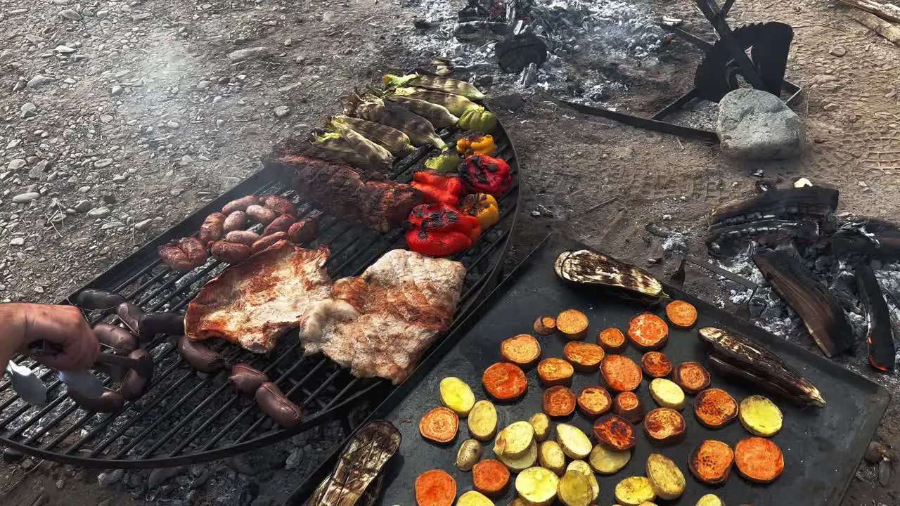 Chef preparing a a delicious grilled vegetables meat and blood sausages in Argentine grill south american grilled style