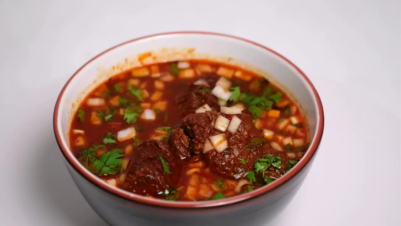 Birria soup with garnish on lazy susan