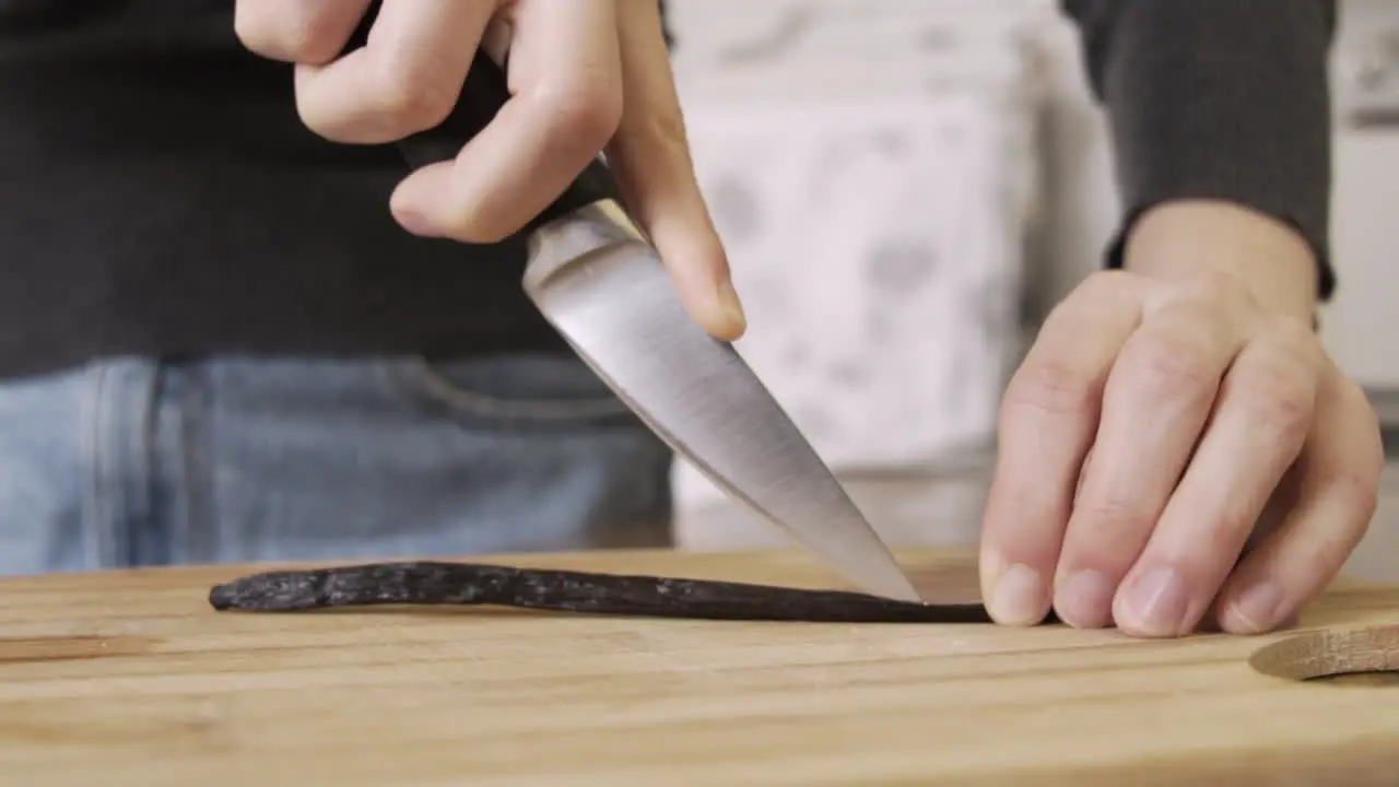 Cutting open a vanilla stick on a chopping board