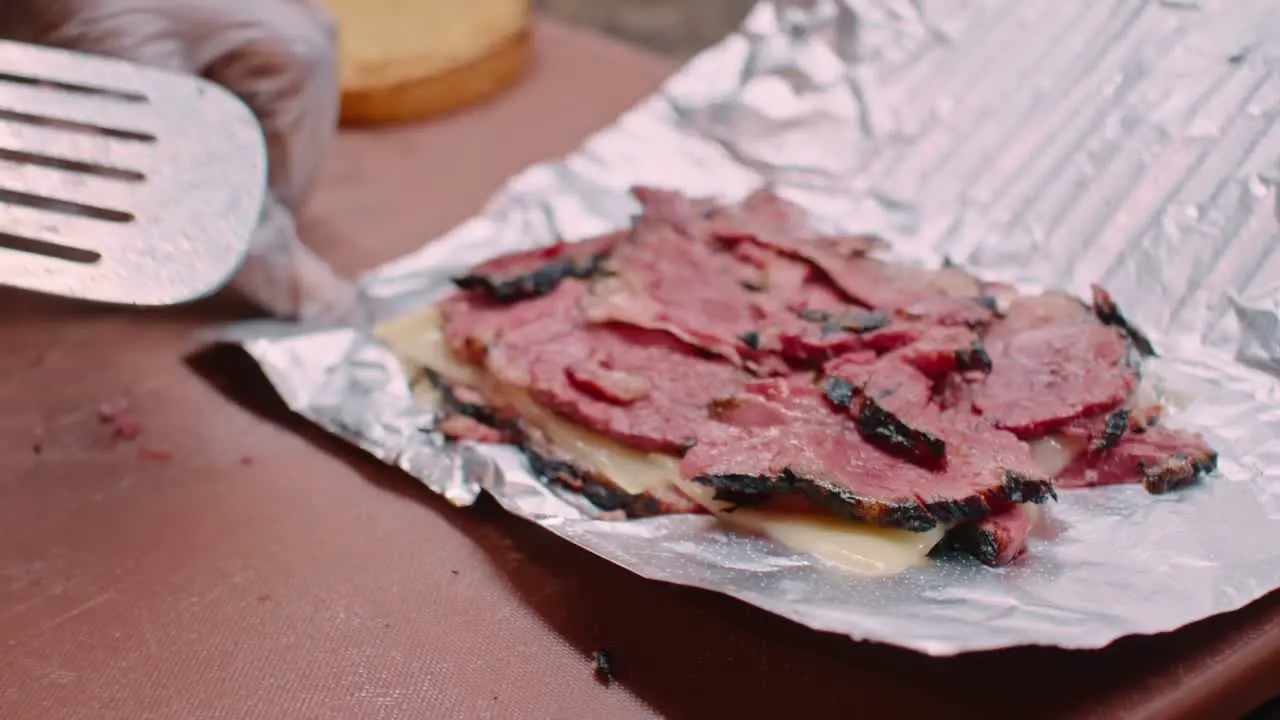 Pastrami meat and cheese on aluminum foil close up