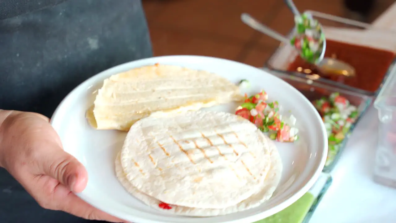 salsa to a quesadilla in restaurant