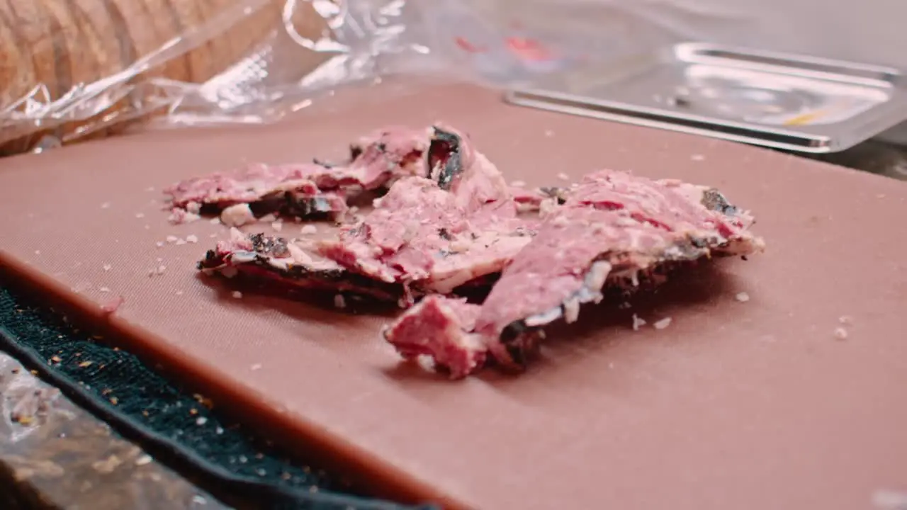 Hands in white gloves preparing pastrami meat for sandwich close up