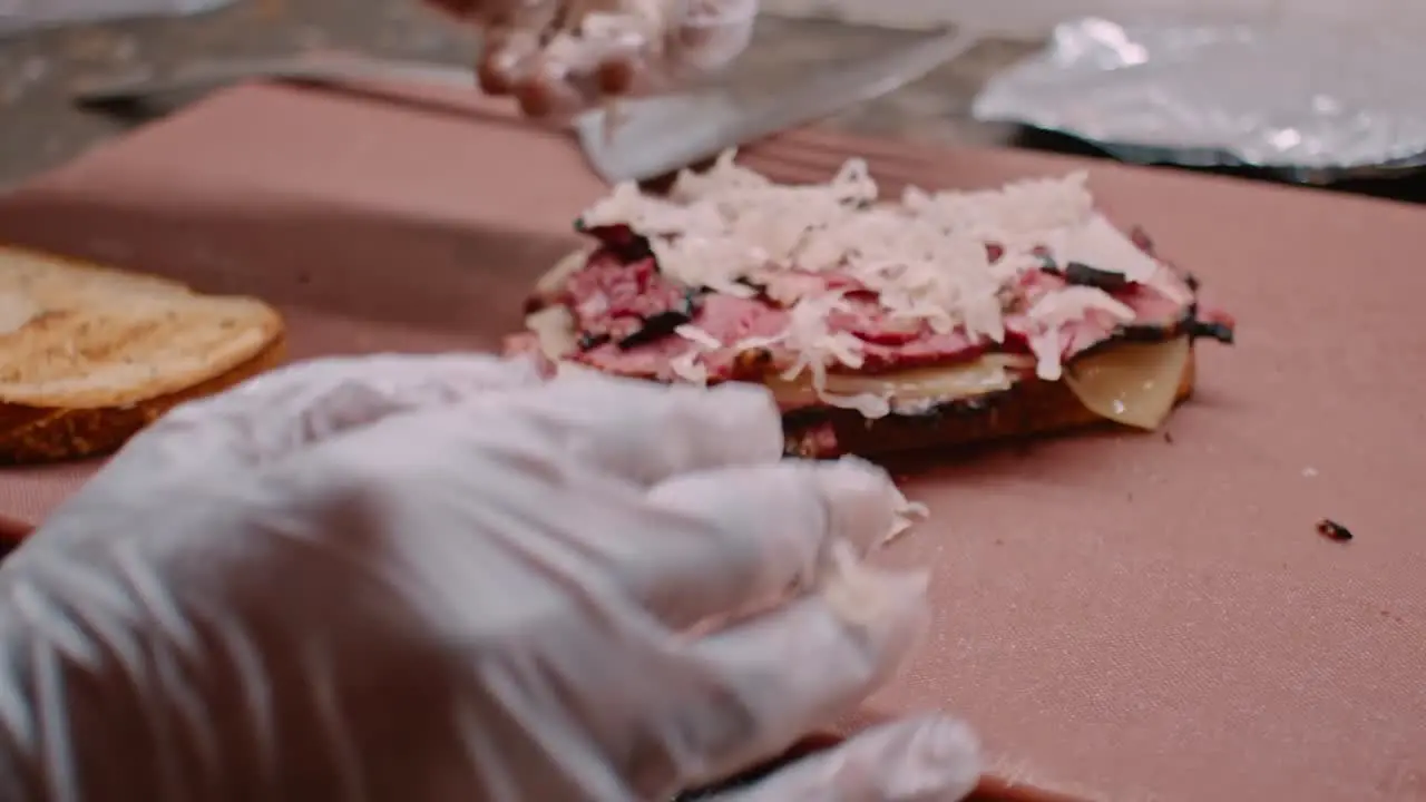 Preparing pastrami sandwich meat and bread close up