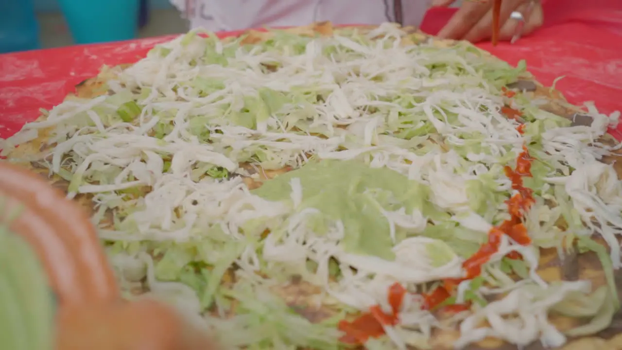 Preparing traditional Food Tlayuda with traditional Oaxaca cheese Quesillo Guacamole salsa