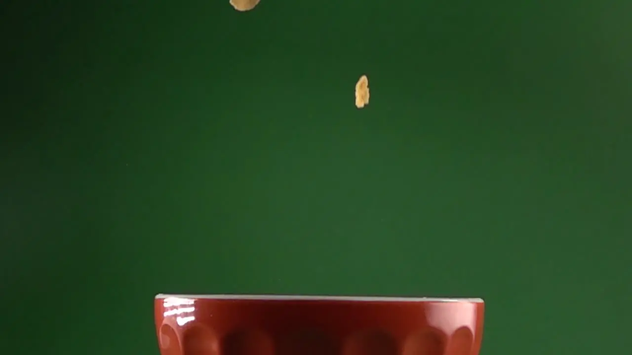 Corn flakes slowly falling on a plate