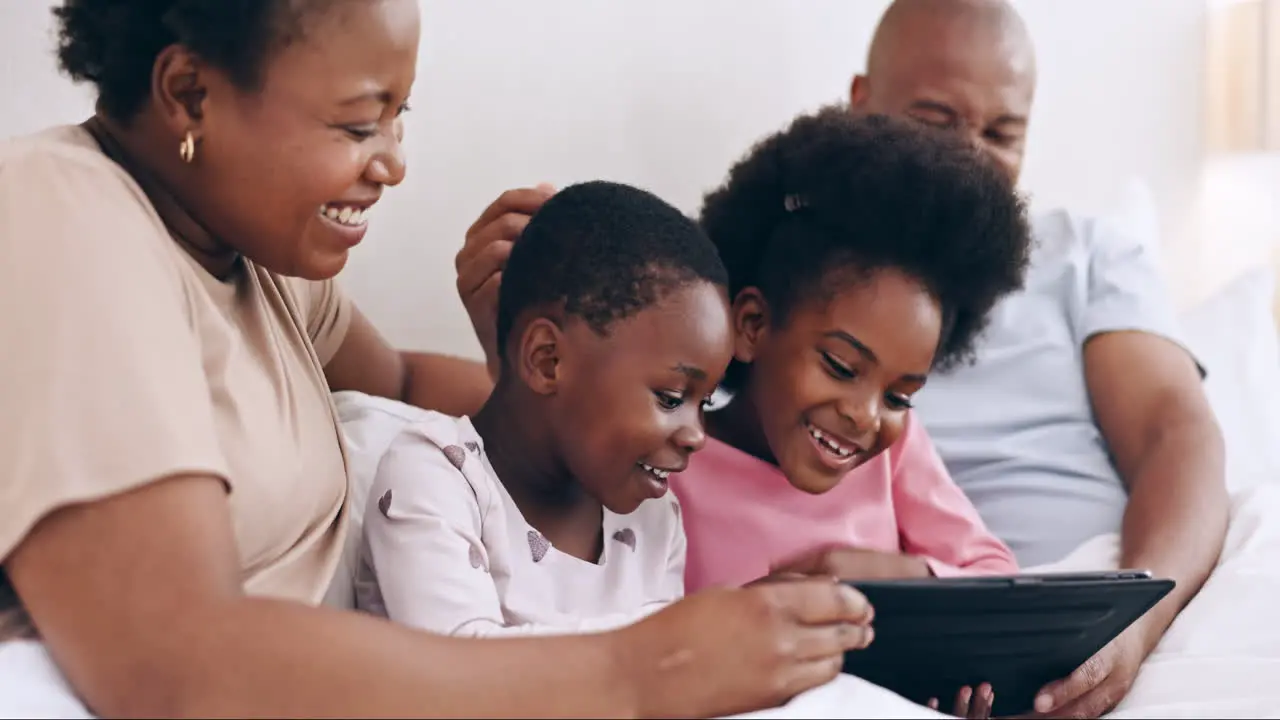 Tablet games and happy black family in a bed