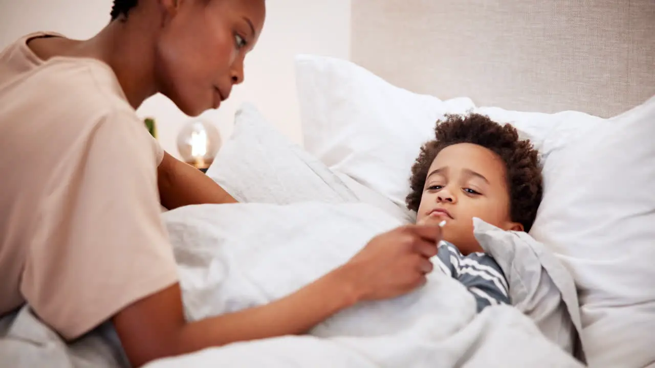 Woman thermometer and sick child in bed