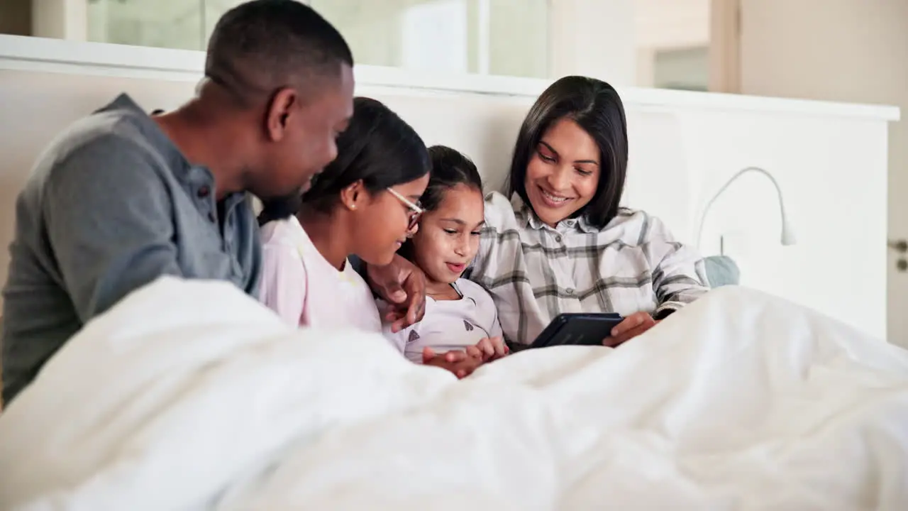 Parents kids and happy family with tablet in bed