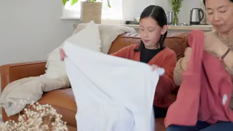 Family girl and mother on a sofa with laundry