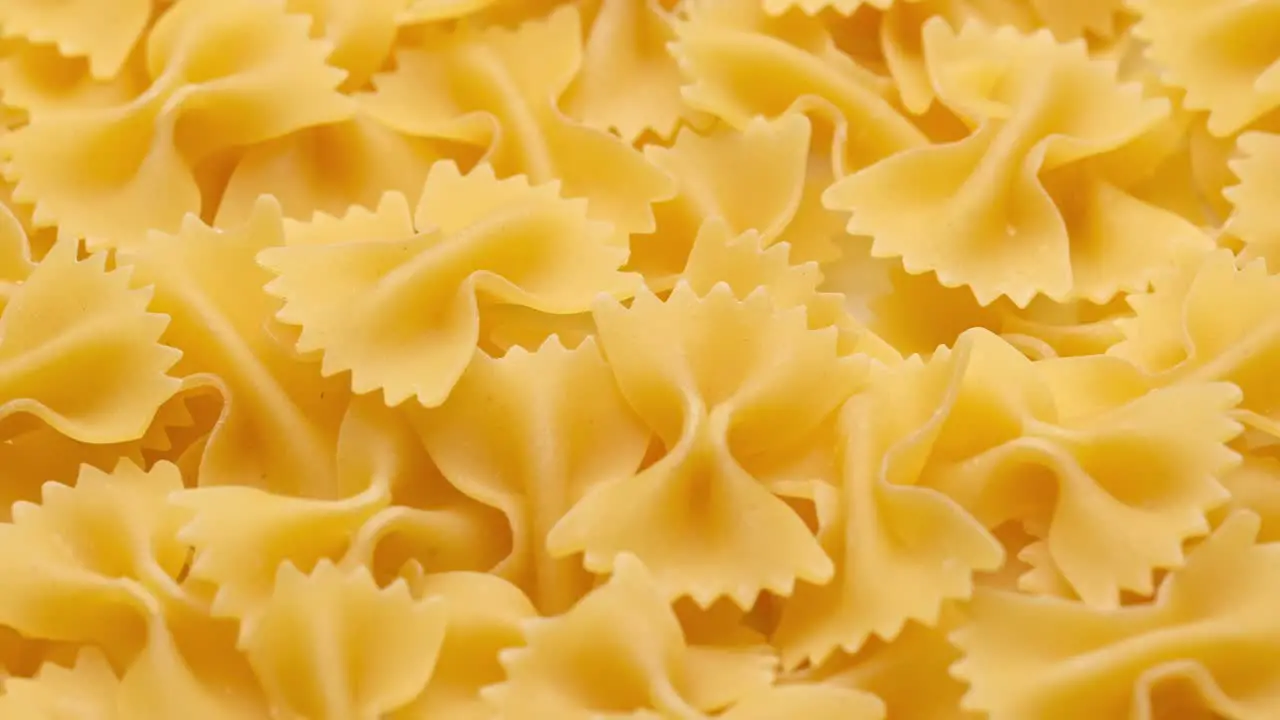 Pile of raw Italian farfalle pasta in motion rotating close-up view food presentation concept