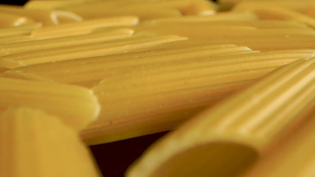 Dolly backward macro Shot Of Italian Pasta Penne on black table