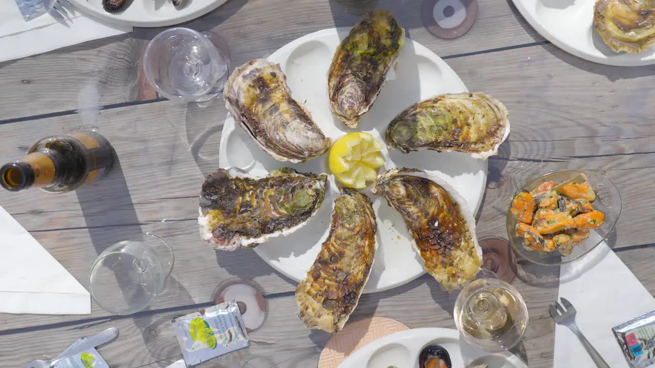 The table is adorned with an exquisite display of oysters their shells glistening with seawater arranged meticulously alongside a selection of fine wines