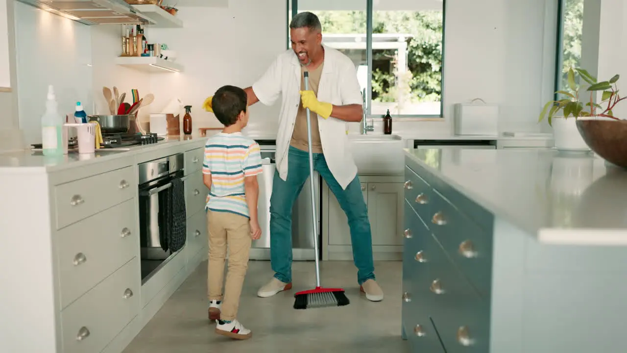 Cleaning dad and child dance in the kitchen