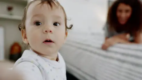 POV of baby taking selfie with mom in family home