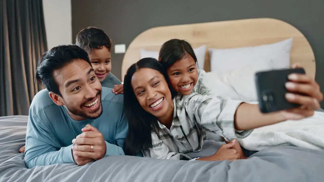 Happy family selfie and bed with parents